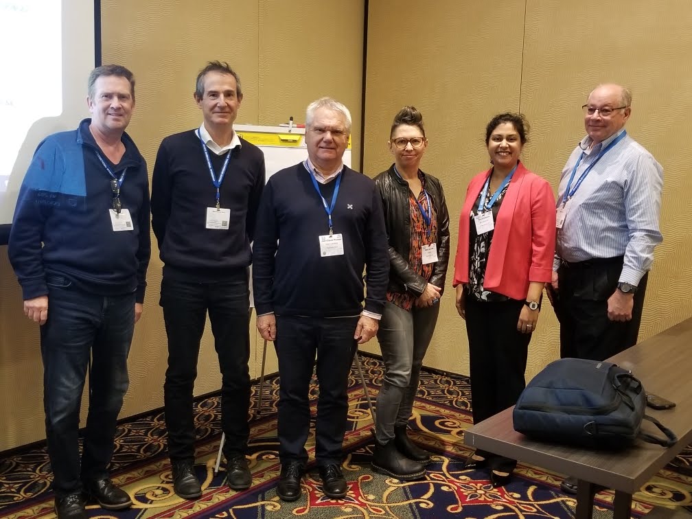 Six PM-SE working group leaders standing together in conference room at IW'23