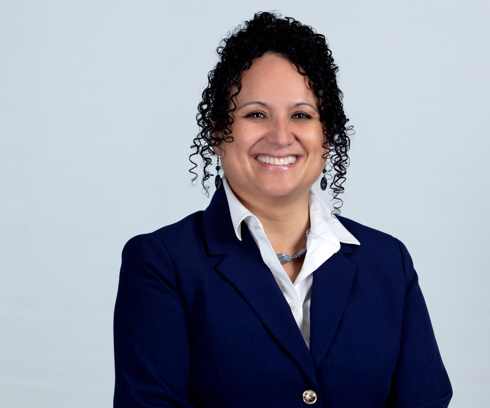 Experienced professional woman smiling in formal business attire for corporate profile image.