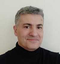 Innovative engineer smiling in a professional headshot for system engineering.