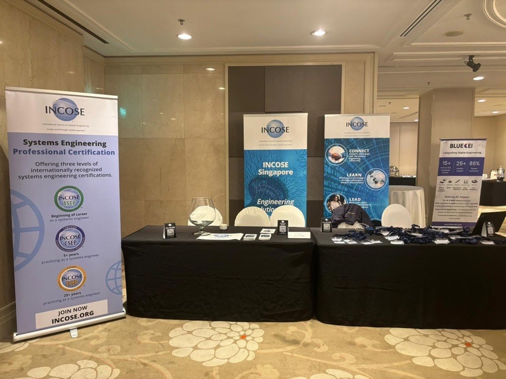INCOSE conference booth with banners and informational materials for systems engineering professionals.