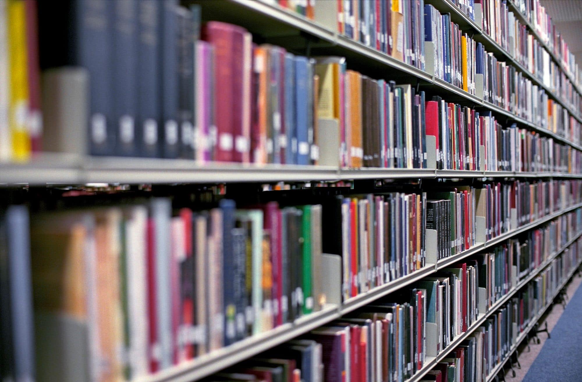 Library shelves filled with colorful books in a public library.