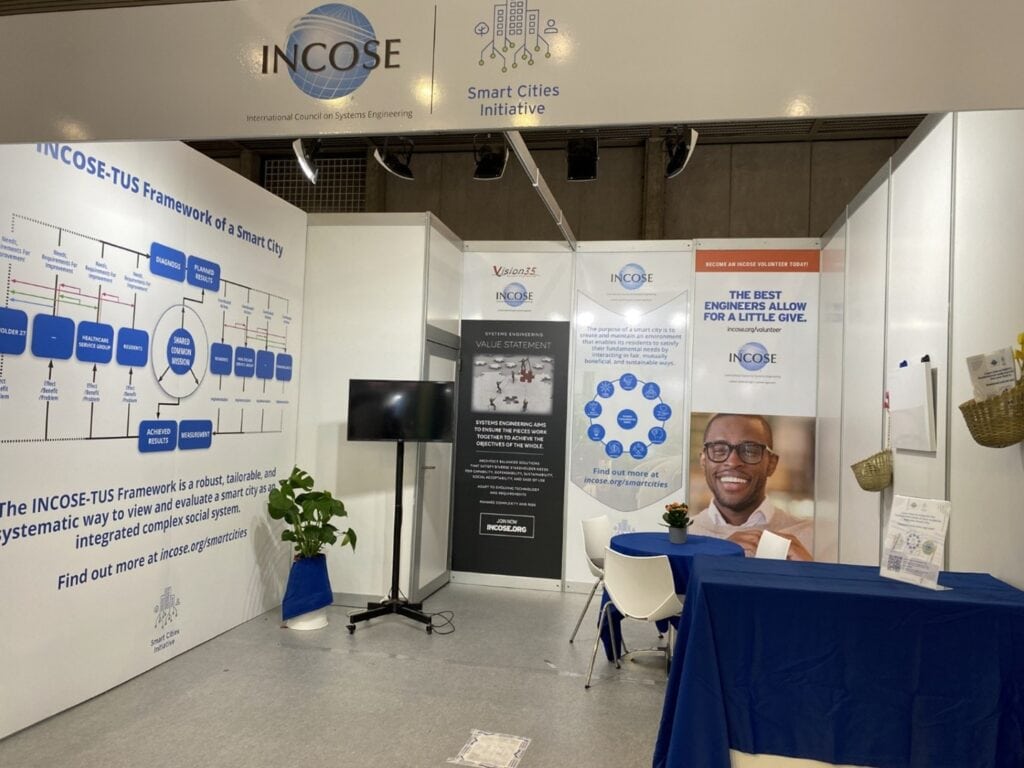INCOSE booth at a conference showcasing smart city engineering and systems frameworks.