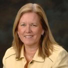 Professional woman smiling in a business setting, representing leadership and expertise.