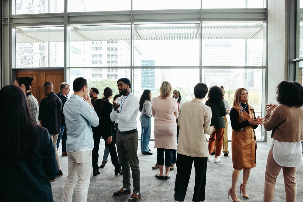 Diverse professionals networking at a modern corporate event in an office lobby.